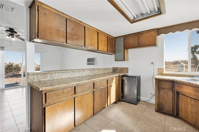 kitchen featuring stainless steel refrigerator, ceiling fan, light tile patterned flooring, and sink