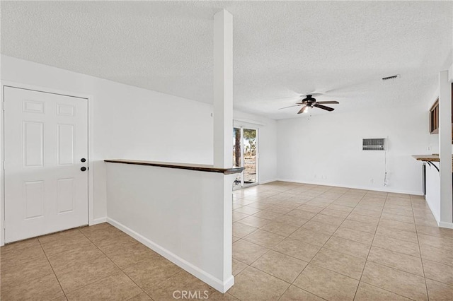 unfurnished living room with ceiling fan, a textured ceiling, and light tile patterned floors