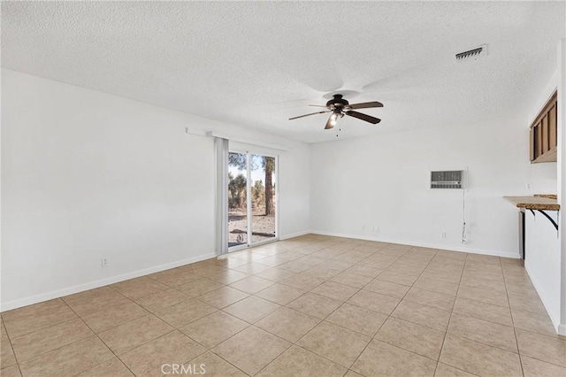 empty room featuring a textured ceiling, ceiling fan, and light tile patterned flooring