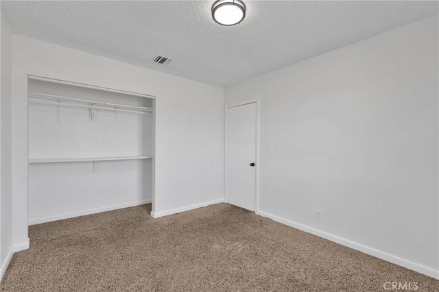 unfurnished bedroom featuring a closet, carpet, and a textured ceiling