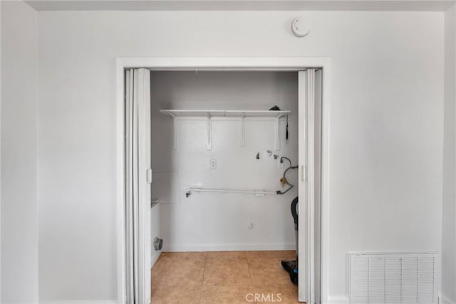 laundry room featuring washer hookup and light tile patterned flooring