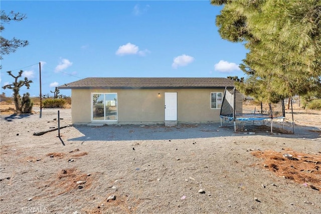 rear view of property with a trampoline