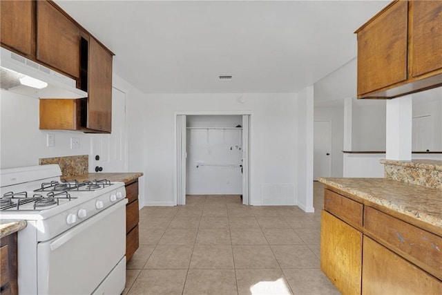 kitchen featuring white gas range and light tile patterned floors