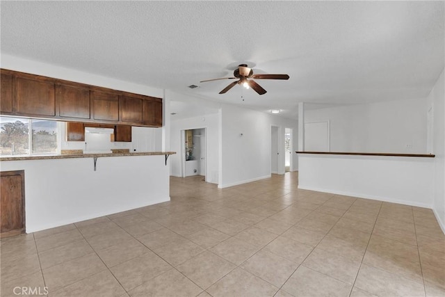 interior space with a textured ceiling and ceiling fan