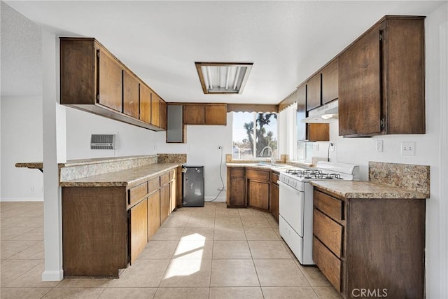 kitchen featuring light tile patterned flooring, sink, and white gas stove