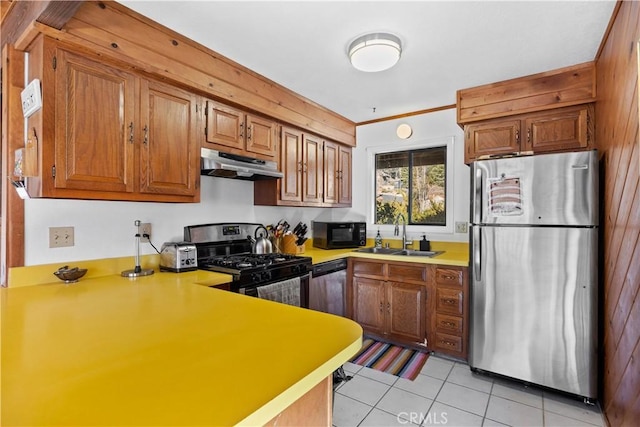 kitchen with sink, light tile patterned floors, stainless steel appliances, ornamental molding, and kitchen peninsula