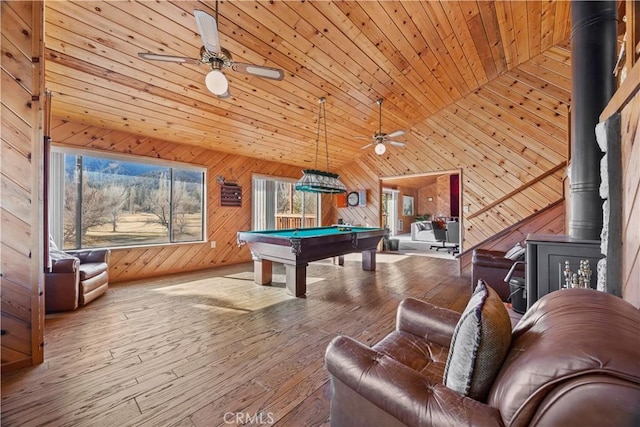 rec room featuring hardwood / wood-style floors, billiards, wood walls, a wood stove, and wood ceiling