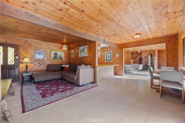 tiled living room featuring wood ceiling, wooden walls, and a wood stove