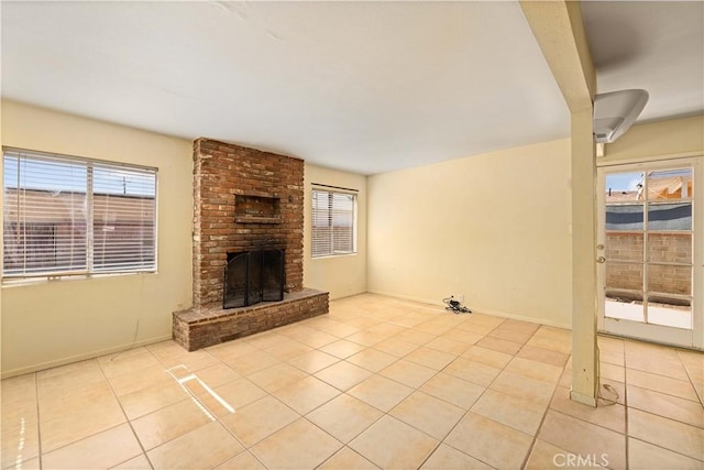 unfurnished living room with a brick fireplace and light tile patterned floors