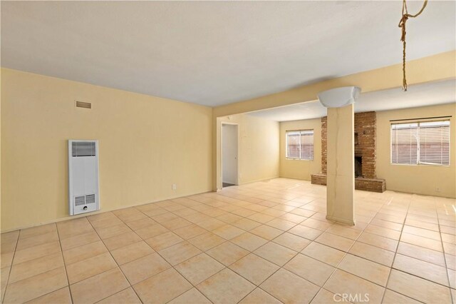 unfurnished living room with a fireplace and light tile patterned floors