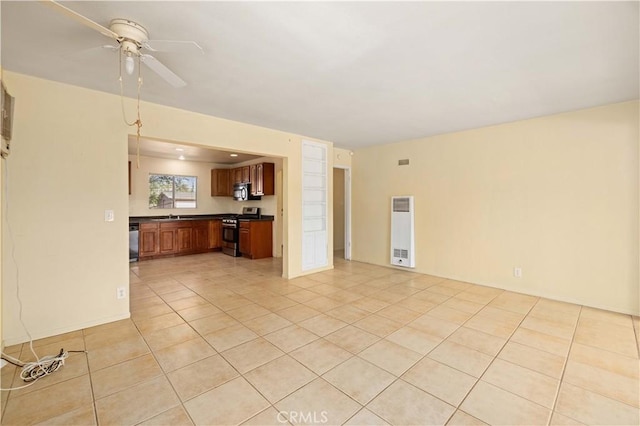 unfurnished living room featuring ceiling fan, sink, and light tile patterned floors