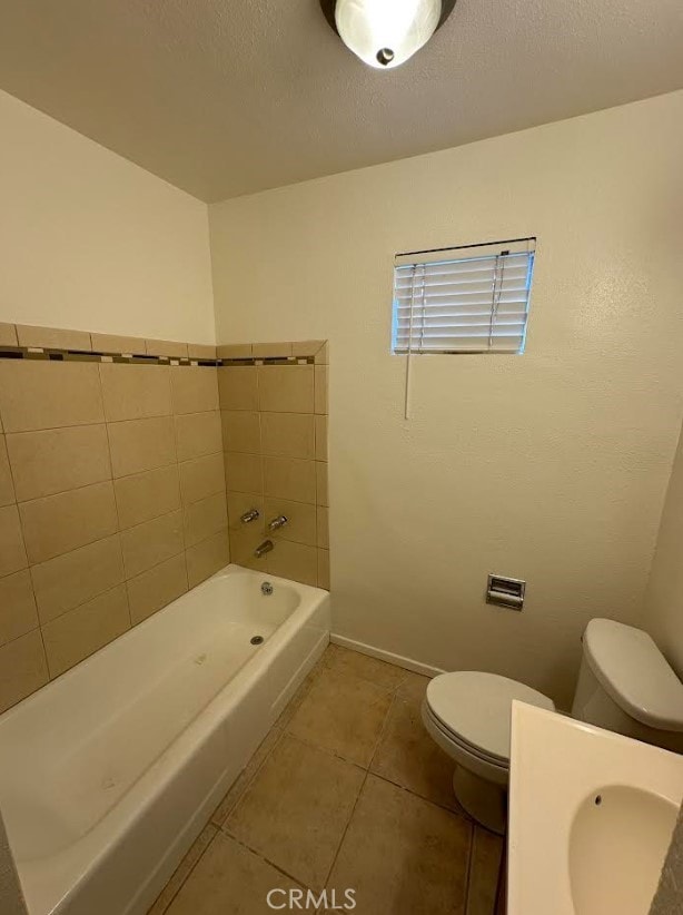 bathroom featuring sink, toilet, tile patterned flooring, and a textured ceiling