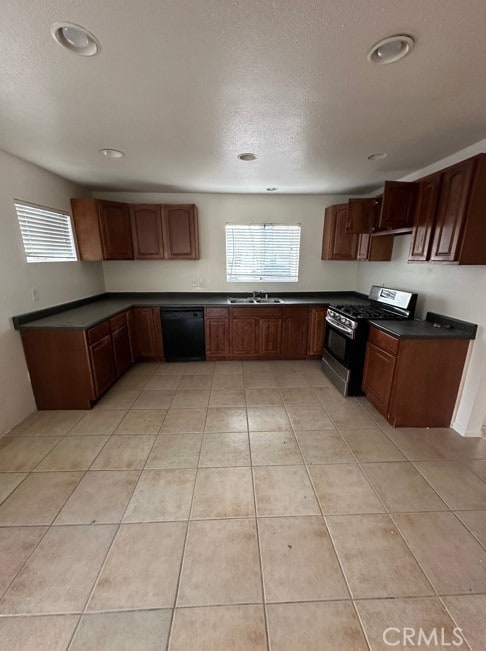 kitchen featuring stainless steel range with gas cooktop, dishwasher, sink, and light tile patterned floors