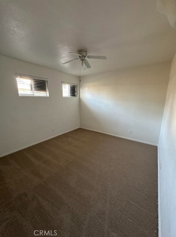 carpeted spare room featuring a textured ceiling and ceiling fan