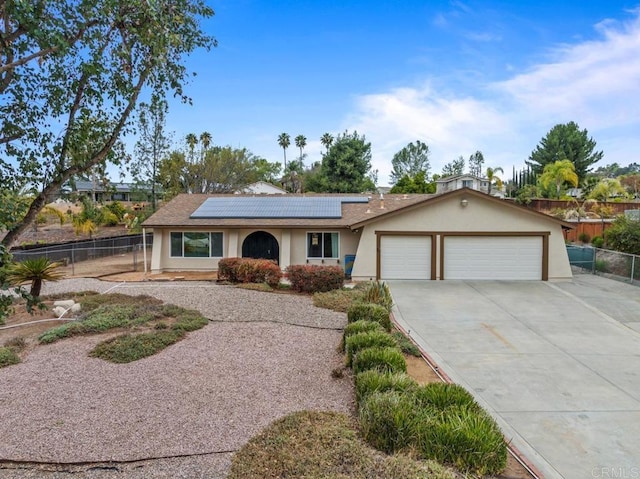 ranch-style home with a garage and solar panels