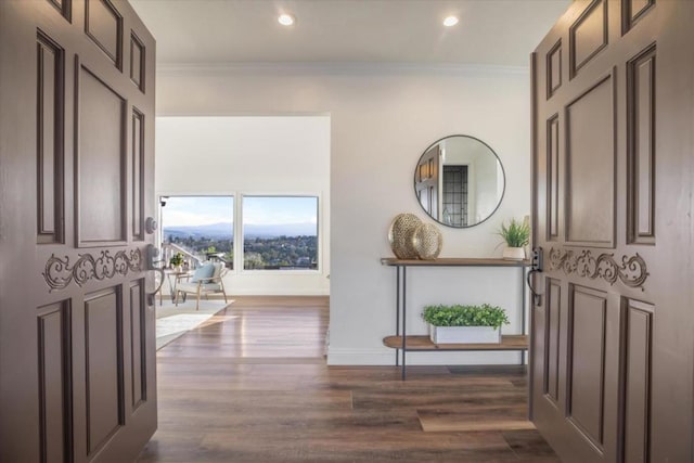 entrance foyer featuring crown molding and dark hardwood / wood-style flooring