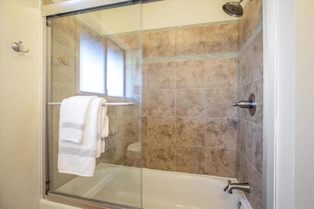 bathroom with bath / shower combo with glass door