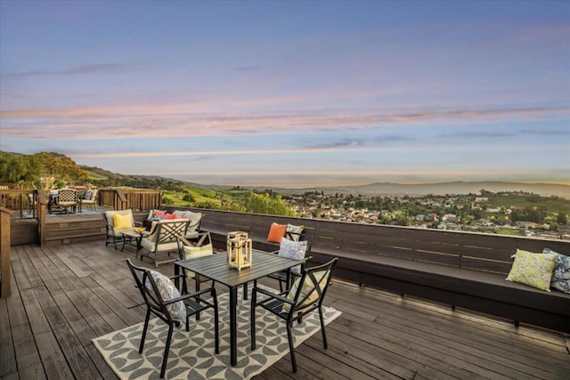 deck at dusk with a mountain view and an outdoor hangout area