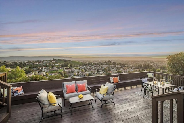 deck at dusk featuring an outdoor hangout area