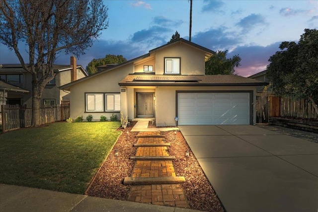 view of front of home with a garage, a lawn, and solar panels