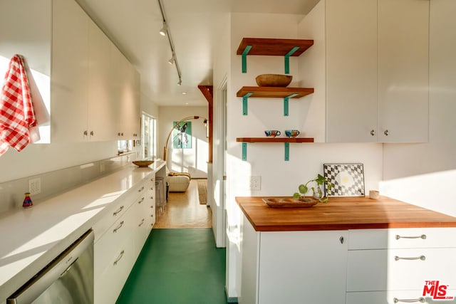 kitchen with white cabinetry, stainless steel dishwasher, track lighting, and wood counters