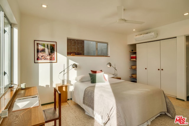 bedroom with ceiling fan, a closet, and a wall unit AC