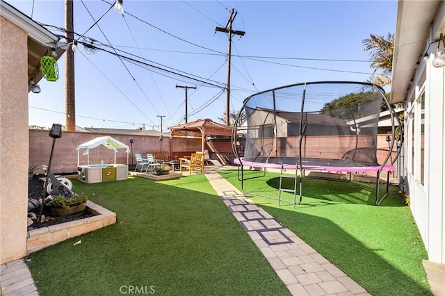 view of yard featuring a trampoline, a gazebo, and a patio