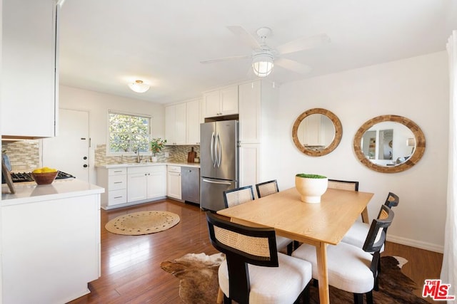 dining room featuring sink, dark wood-type flooring, and ceiling fan