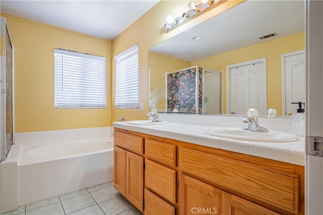 bathroom featuring tile patterned flooring, vanity, and shower with separate bathtub