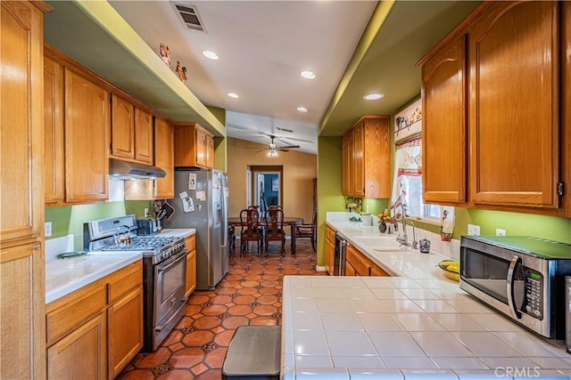 kitchen featuring appliances with stainless steel finishes, sink, tile counters, ceiling fan, and tile patterned floors