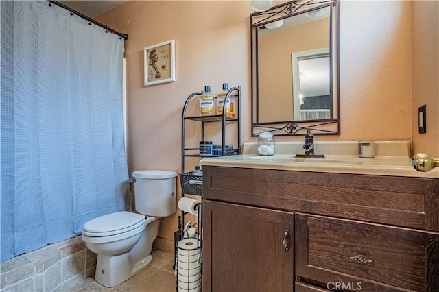 bathroom featuring tile patterned flooring, vanity, walk in shower, and toilet