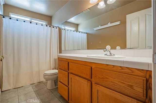 bathroom featuring tile patterned flooring, vanity, and toilet