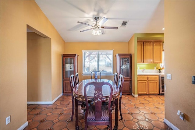 tiled dining space featuring ceiling fan and beverage cooler