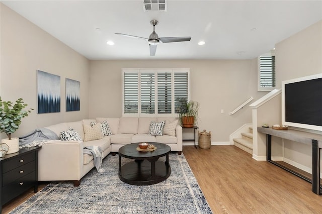 living room with ceiling fan, a wealth of natural light, and light wood-type flooring