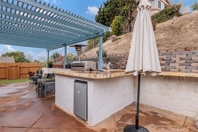 view of patio / terrace with exterior kitchen, grilling area, and a pergola