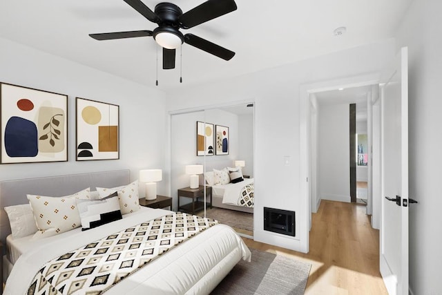 bedroom with ceiling fan, light wood-type flooring, and a closet