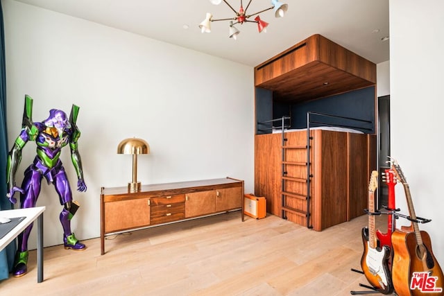 bedroom with an inviting chandelier and light wood-type flooring