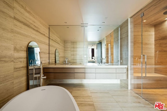 bathroom with independent shower and bath, vanity, and tile walls