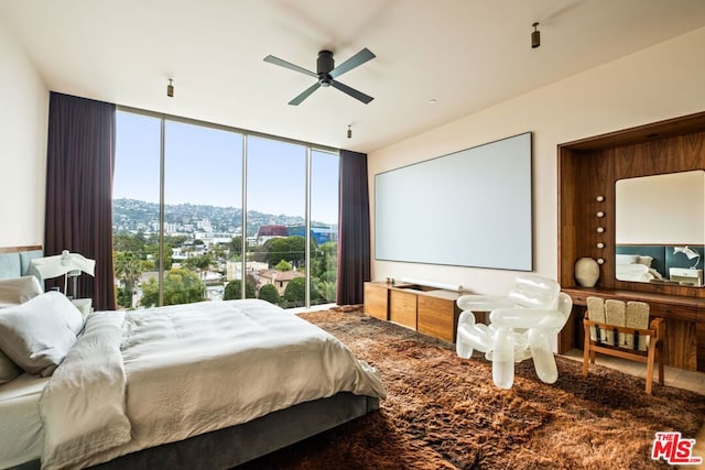 bedroom with ceiling fan and a wall of windows