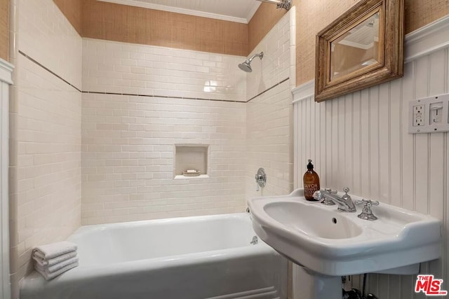 bathroom featuring tiled shower / bath combo, ornamental molding, and sink