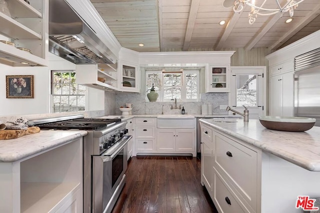 kitchen featuring white cabinetry, sink, high end range, light stone counters, and wall chimney range hood