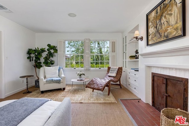 sitting room with a fireplace and built in features