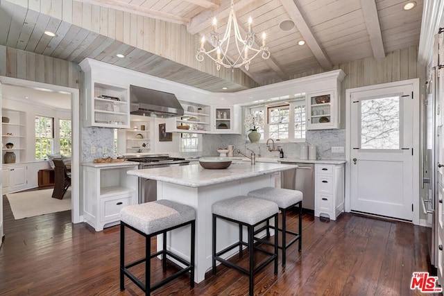 kitchen with white cabinetry, a kitchen island, and wall chimney exhaust hood