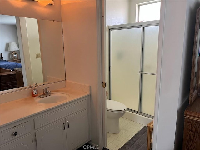 bathroom featuring vanity, toilet, and walk in shower