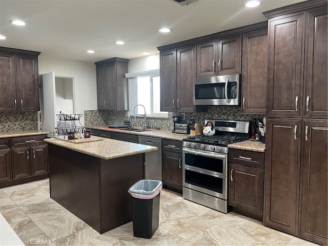 kitchen with dark brown cabinets, stainless steel appliances, sink, and a kitchen island