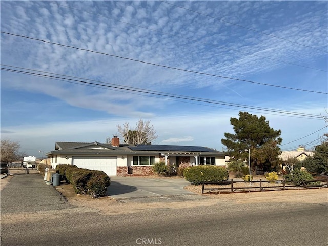 view of front of property featuring a garage and solar panels