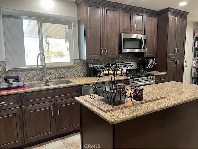 kitchen with tasteful backsplash, stainless steel appliances, a center island, and sink