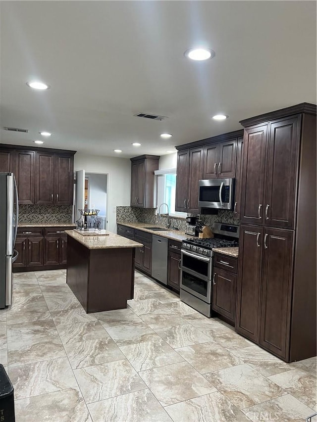 kitchen featuring appliances with stainless steel finishes, a center island, sink, and dark brown cabinets