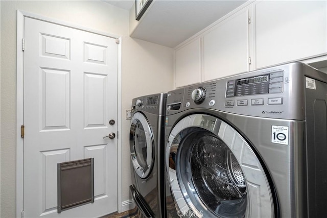 laundry area with washer and clothes dryer and cabinets