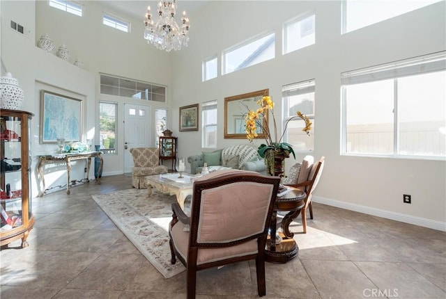 dining space featuring a towering ceiling and an inviting chandelier